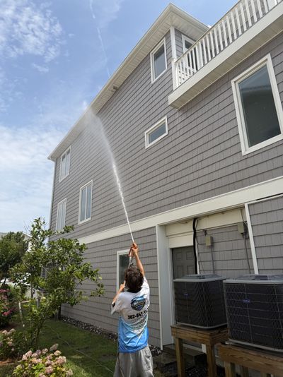 A Loukides Power Washing technician soft washing a home's siding