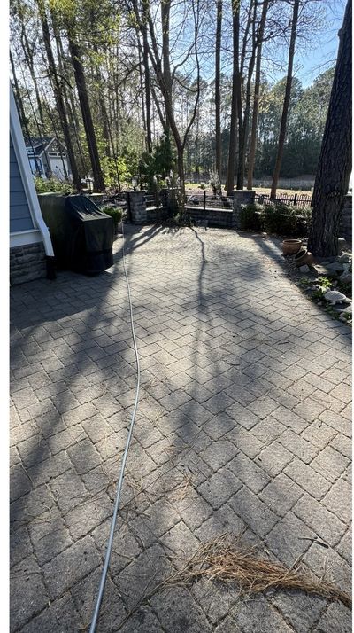 Paver patio covered in dirt and pine needles before cleaning